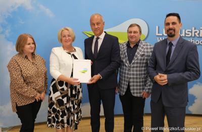 Członek Zarządu Województwa Lubuskiego Marcin Jabłoński (trzeci z prawej) wręcza umowy przedstawicielom gmin i lubuskich powiatów 