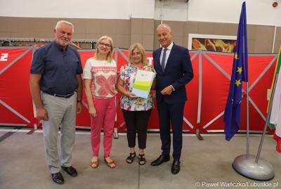 Członek zarządu województwa lubuskiego Marcin Jabłoński (z prawej) oraz radna woj. lubuskiego Małgorzata Paluch-Słowińska (z lewej) z przedstawicielami lubuskiej gminy, która otrzyma dofinansowanie na zadania własne z zakresu ochrony przeciwpożarowej