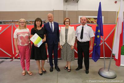 Członek zarządu województwa lubuskiego Marcin Jabłoński (w środku) oraz radna woj. lubuskiego Małgorzata Paluch-Słowińska (z lewej) z przedstawicielami lubuskiej gminy, która otrzyma dofinansowanie na zadania własne z zakresu ochrony przeciwpożarowej