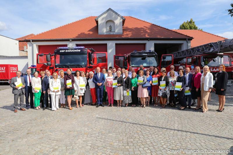 Członek zarządu województwa lubuskiego Marcin Jabłoński oraz radna woj. lubuskiego Małgorzata Paluch-Słowińska na pamiątkowym zdjęciu z przedstawicielami lubuskich gmin, które otrzymają dofinansowanie na zadania własne z zakresu ochrony przeciwpożarowej