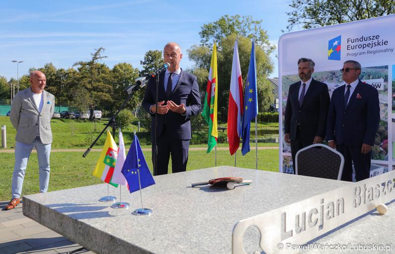 Członek zarządu województwa lubuskiego Marcin Jabłoński (przy mikrofonie) przemawia podczas konferencji prasowej w WOSiR w Drzonkowie