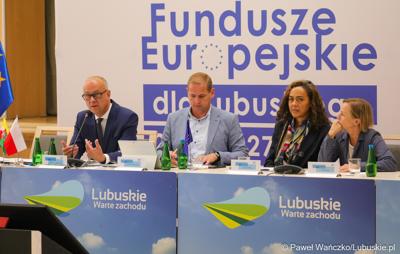 Stół prezydialny Komitetu Minitorującego Fundusze Europejskie dla Lubuskiego 2021-2027. Od lewej: Członek  Zarządu Województwa Lubuskiego Marcin Jabłoński, Wicemarszałek Województwa Lubuskiego Łukasz Porycki oraz Cinzia Masina, Zastępca Dyrektora Wydziału ds. Polski, Czech i Słowacji w Dyrekcji Generalnej ds. Zatrudnienia, Spraw Społecznych i Włączenia Społecznego Komisji Europejskiej 