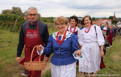 Marszałek Elżbieta Anna Polak oraz  rektor Uniwersytetu Zielonogórskiego prof. Wojciech Strzyżewski idą w korowodzie podczas VIII Winobrania na Winnicy Samorządowej w Zaborze 