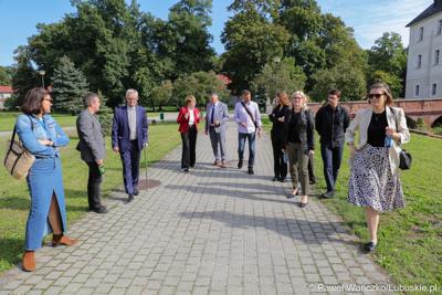 Marszałek Elżbieta Anna Polak (w czerwonym żakiecie), wraz z uczestnikami konferencji, obok pałacu w Zaborze