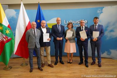 Marszałek Województwa Lubuskiego Marcin Jabłoński (w środku) oraz dyrektor Departamentu Programów Regionalnych UMWL Marek Kamiński (z lewej) wraz z beneficjentami funduszy europejskich w ramach perspektywy finansowej Regionalnego Programu Operacyjnego Lubuskie 2020. 