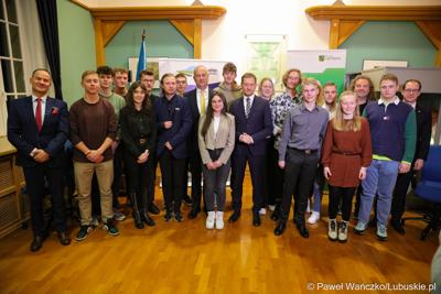Uczestnicy debaty w sali posiedzeń ratusza w Weißwasser pozują do pamiątkowego zdjęcia z Marszałkiem Województwa Lubuskiego Marcinem Jabłońskim oraz premierem Wolnego Kraju Saksonia Michaelem Kretschmerem.