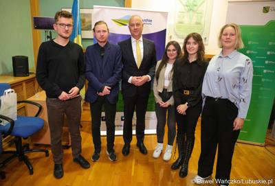 Uczestnicy debaty w sali posiedzeń ratusza w Weißwasser pozują do pamiątkowego zdjęcia z Marszałkiem Województwa Lubuskiego Marcinem Jabłońskim 
