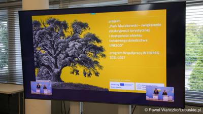 Monitor z prezentacją podczas konferencji prasowej dot. Święta Parku Mużakowskiego, które odbędzie się w dniach 22-23 czerwca