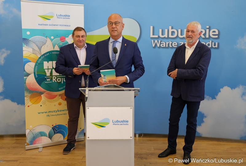 Marszałek Województwa Lubuskiego Marcin Jabłoński przemawia podczas konferencji prasowej poświęconej najnowszej edycji Festiwalu Muzyka w Raju (14 – 24 sierpnia 2024). Z tyłu stoją Wicemarszałek Województwa Lubuskiego Grzegorz Potęga i Prezes Zarządu Fundacji Muzyki Dawnej CANOR Cezary Zych