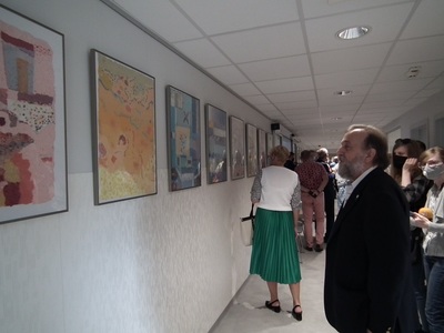 Autor obrazów i dziennikarze oglądający wystawę artystyczną "O" na oddziele onkologicznym szpitala
