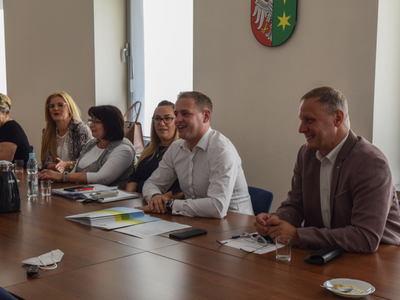 Zdjęcie ze spotkania; osoby rozmawiające przy stole w sali konferencyjnej.