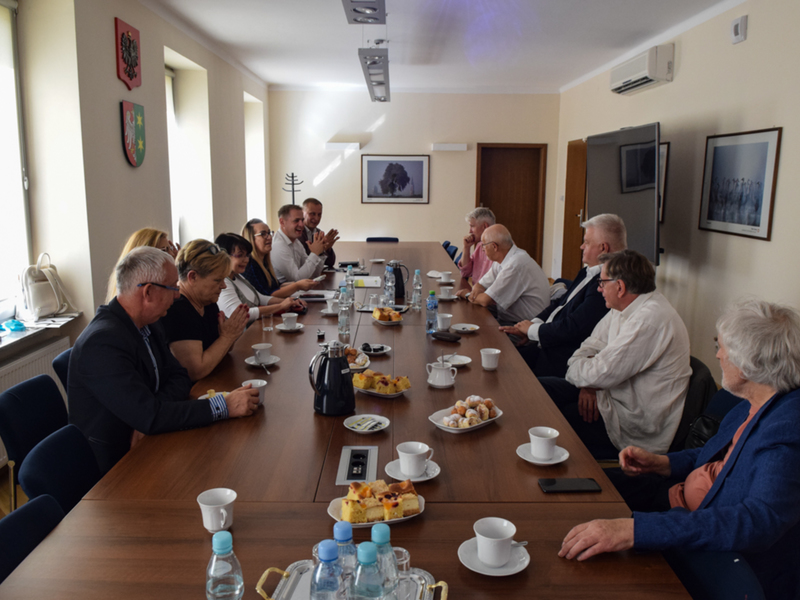 Zdjęcie ze spotkania; osoby rozmawiające przy stole w sali konferencyjnej.