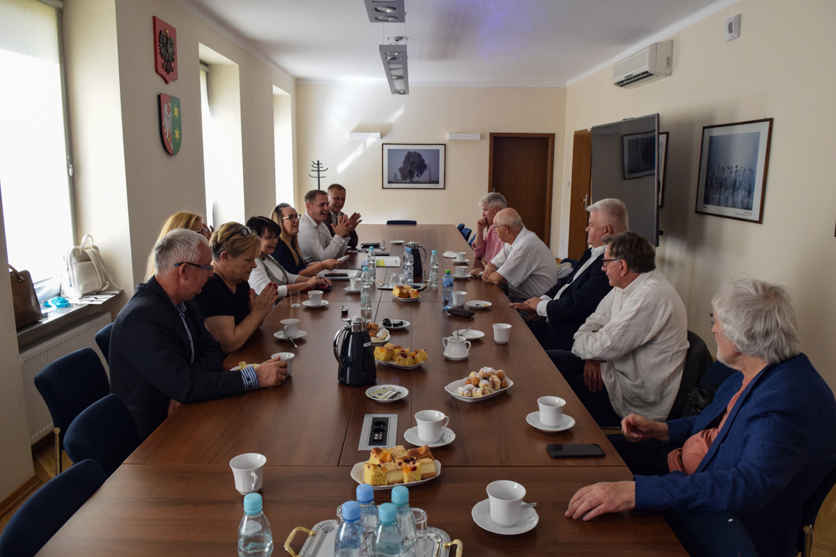 Zdjęcie ze spotkania; osoby rozmawiające przy stole w sali konferencyjnej.