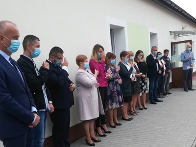 Sznur ludzi pod ścianą.