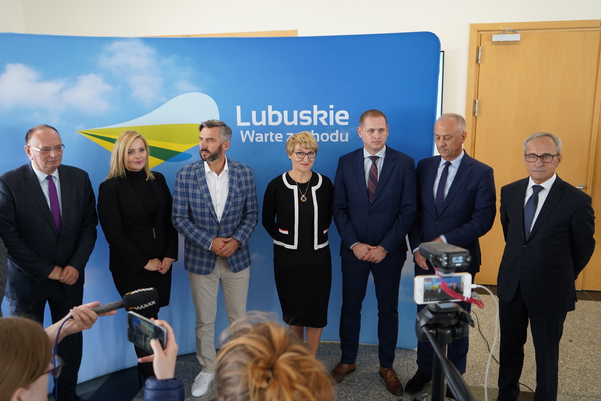 Uczestnicy konferencji prasowej na tle ścianki z logiem województwa lubuskiego.