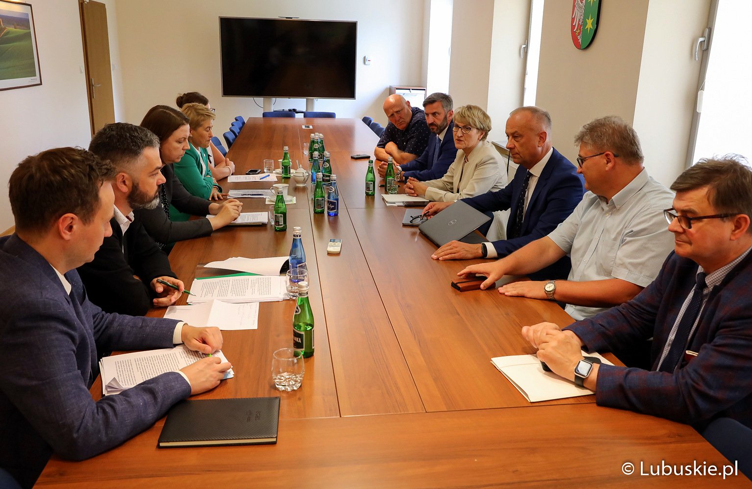 Uczestnicy spotkania siedzą przy stole i rozmawiają.