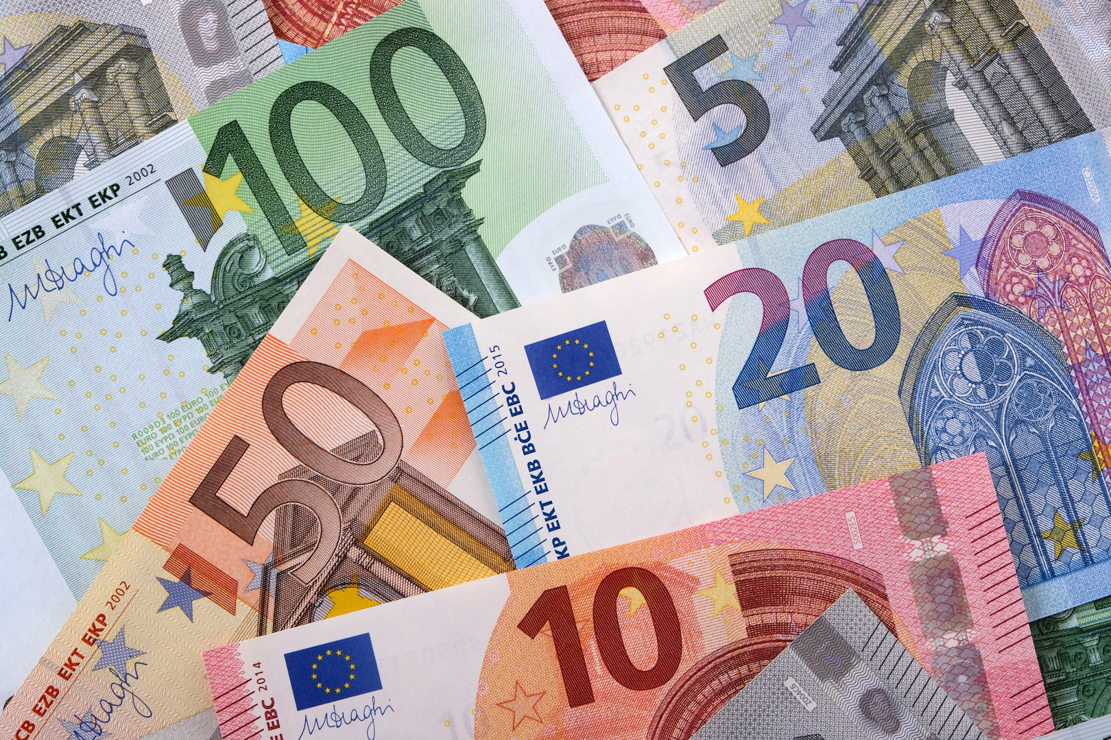 Rozrzucone banknoty euro o nominałach od 5 do 100 euro.