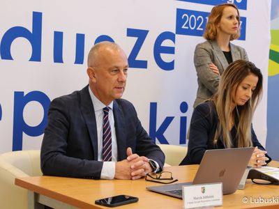 Członek zarządu województwa, Marcin Jabłoński podczas konsultacji projektu programu Fundusze Europejskie Województwa Lubuskiego 2021-2027, które odbyły się formule online. Obok (siedzi) dyr. Departamentu Zarządzania Regionalnym Programem Operacyjnym, Sylwia Pędzińska.