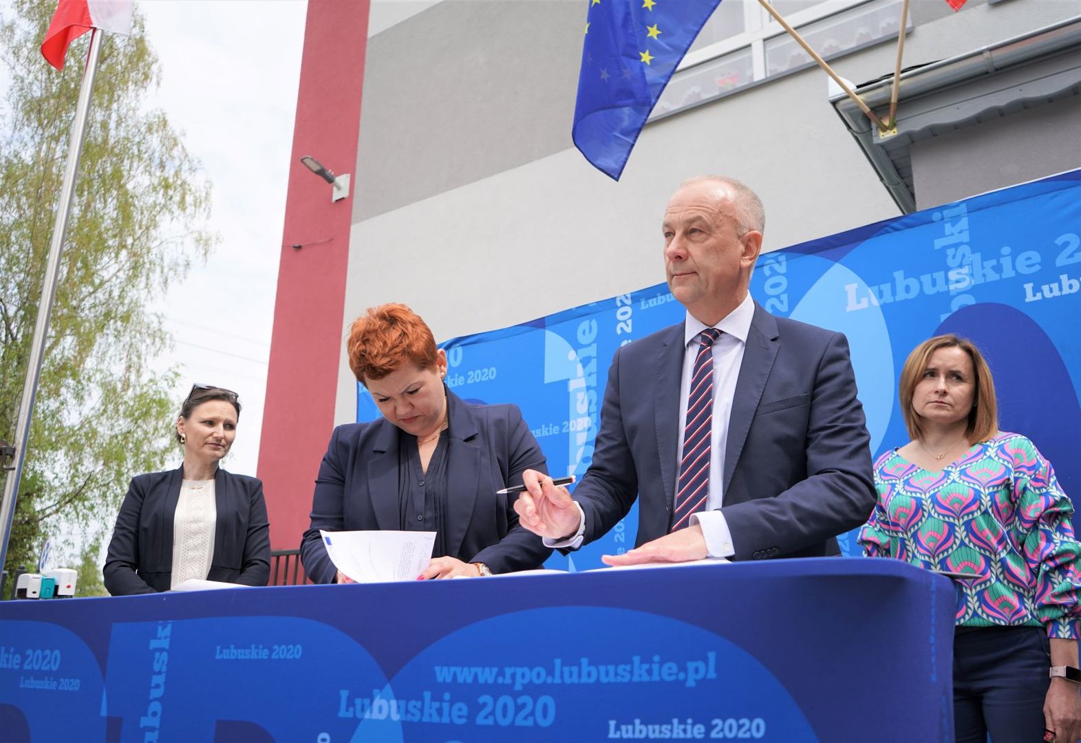 W podpisaniu aneksu do umowy RPO-L2020 na realizację projektu dotyczącego termomodernizacji budynku Zespołu Szkolno-Przedszkolnego w Lipinkach Łużyckich wzięli udział: Marcin Jabłoński - Członek Zarządu Województwa Lubuskiego, Małgorzata Brzyśkiewicz - Wójt Gminy Lipinki Łużyckie, Jarosław Bumbul - Przewodniczący Rady Gminy Lipinki Łużyckie, Iwona Żychowska - Skarbnik Gminy Lipinki Łużyckie, Elżbieta Serwatka - Dyrektor Zespołu Szkolno – Przedszkolnego w Lipinkach Łużyckich, Ma
