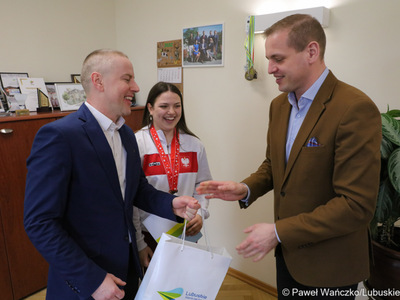 Wicemarszałek Województwa Lubuskiego Łukasz Porycki składa gratulacje zawodniczce Klubu Karate Kontra w Żarach Martynie Grajcar oraz jej trenerowi Sebastianowi Końcowikowi