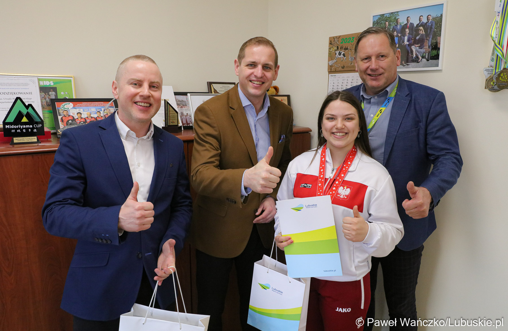 Wicemarszałek Województwa Lubuskiego Łukasz Porycki (w środku), zawodniczka Klubu Karate Kontra w Żarach Martyna Grajcar, jej trener Sebastian Końcowik (z lewej) oraz zastępca dyrektora departamentu Infrastruktury Społecznej UMWL Andrzej Ziarek.